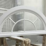 Curved timber window painted white