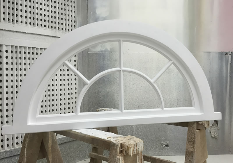 Curved timber window painted white
