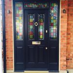 Black entrance door with stained decorative glass