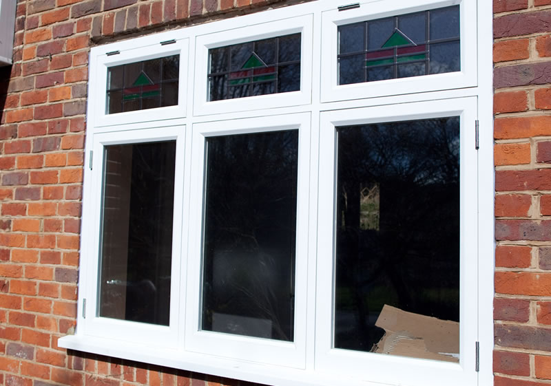 Timber casement windows with lead details and coloured glass pattern